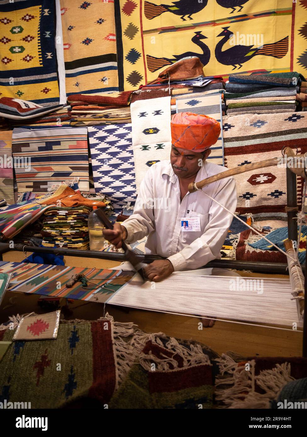 Udaipur, India - 29 dicembre 2022 : uomo Rajasthani vecchio e non identificato, in abbigliamento tradizionale, che crea tappeti a mano Foto Stock