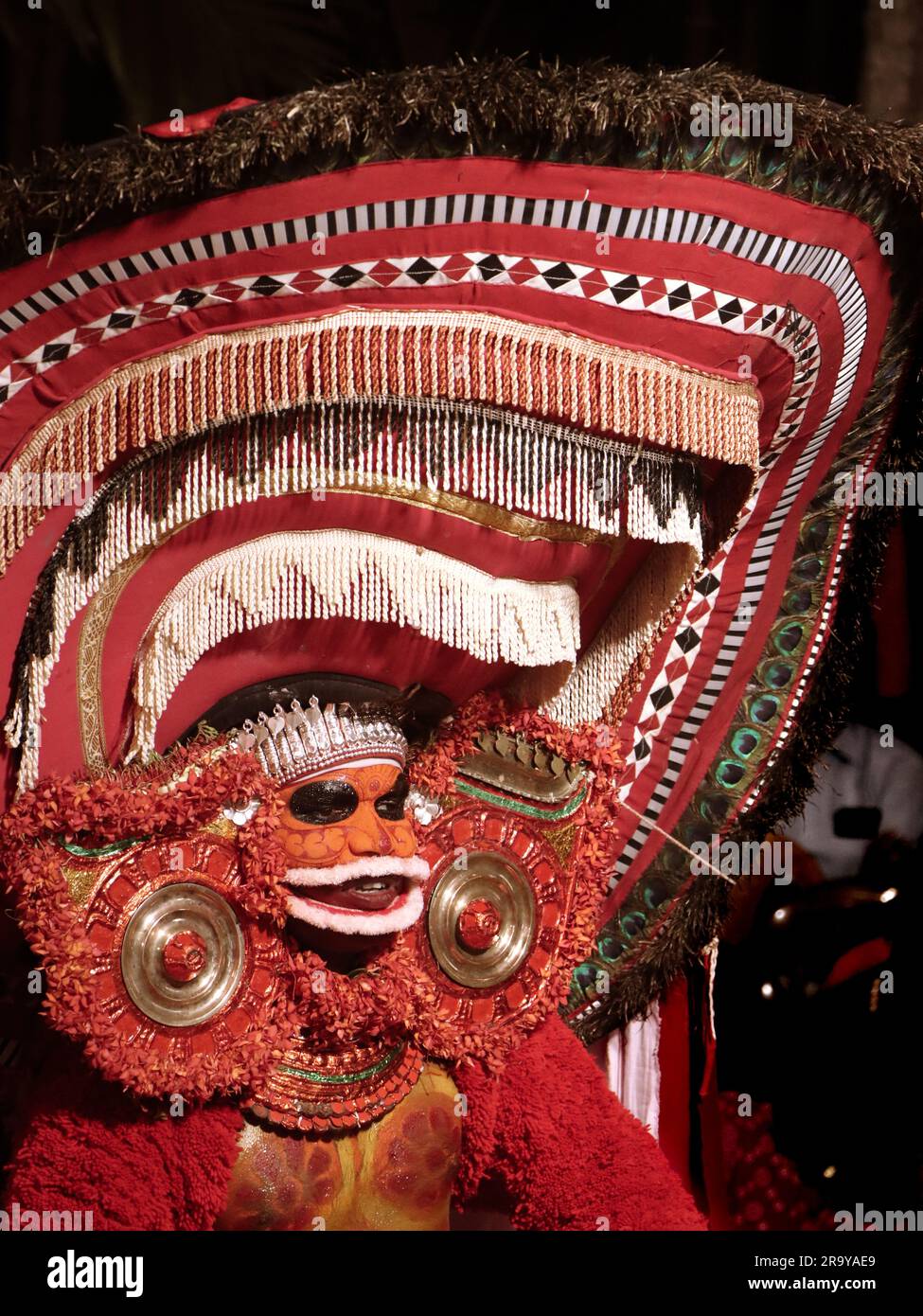 theyam, una popolare forma d'arte di culto praticata in kerala eseguita da un artista in costume tradizionale durante il festival del tempio come rituale Foto Stock