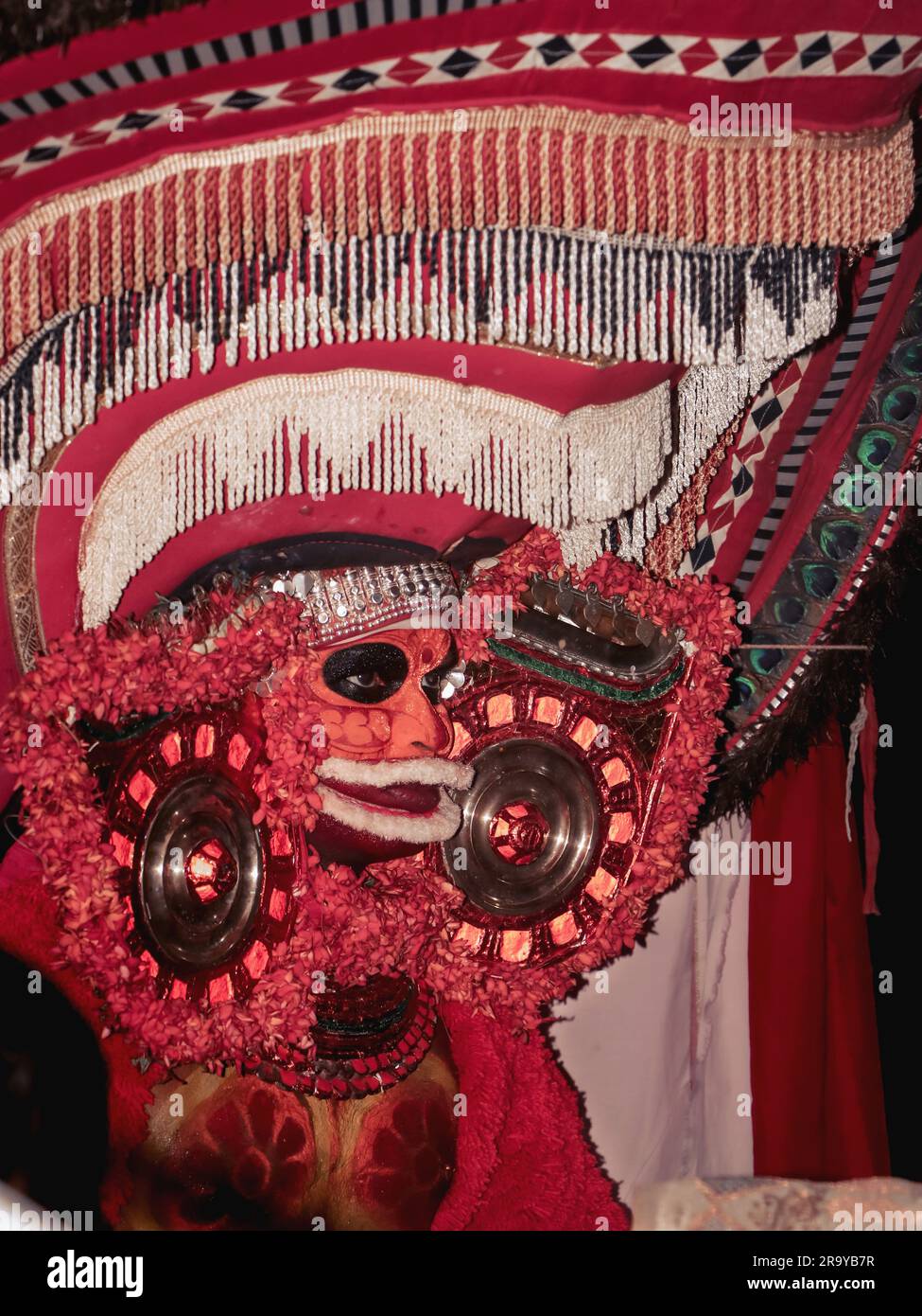 theyam, una popolare forma d'arte di culto praticata in kerala eseguita da un artista in costume tradizionale durante il festival del tempio come rituale Foto Stock