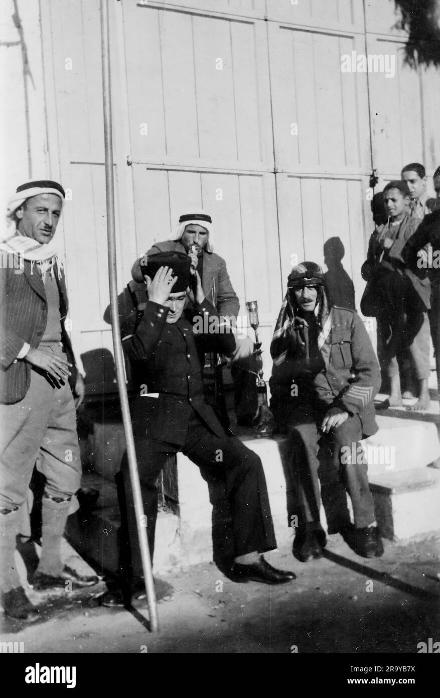 Un soldato che indossa il cappello, circondato da arabi. Palestina, c1930. Si tratta di una fotografia tratta da un album di scatti, durante l'occupazione della Palestina da parte dell'esercito britannico, con foto provenienti dalla Palestina e dal Regno Unito, tra cui devil's Jump vicino a Churt nel Surrey e devil's Punch Bowl. L'addestramento sembra essere a Hursley Camp, vicino a Winchester. La Gran Bretagna amministrò la Palestina per conto della società delle Nazioni tra il 1920 e il 1948, un periodo denominato "mandato britannico”. Foto Stock