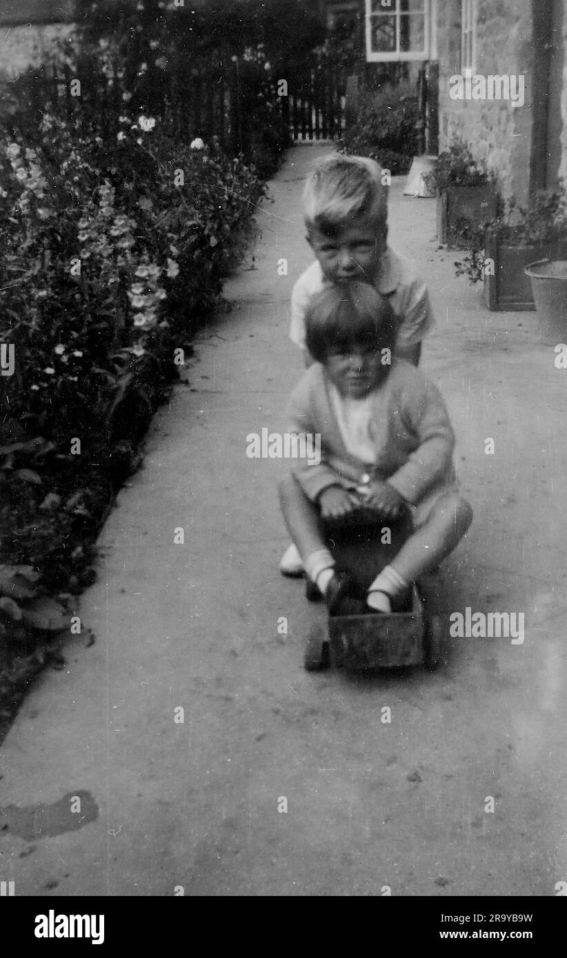 Un ragazzo che spinge una ragazza su un carrello. Surrey, c1930. Si tratta di una fotografia tratta da un album di scatti, durante l'occupazione della Palestina da parte dell'esercito britannico, con foto provenienti dalla Palestina e dal Regno Unito, tra cui devil's Jump vicino a Churt nel Surrey e devil's Punch Bowl. L'addestramento sembra essere a Hursley Camp, vicino a Winchester. La Gran Bretagna amministrò la Palestina per conto della società delle Nazioni tra il 1920 e il 1948, un periodo denominato "mandato britannico”. Foto Stock