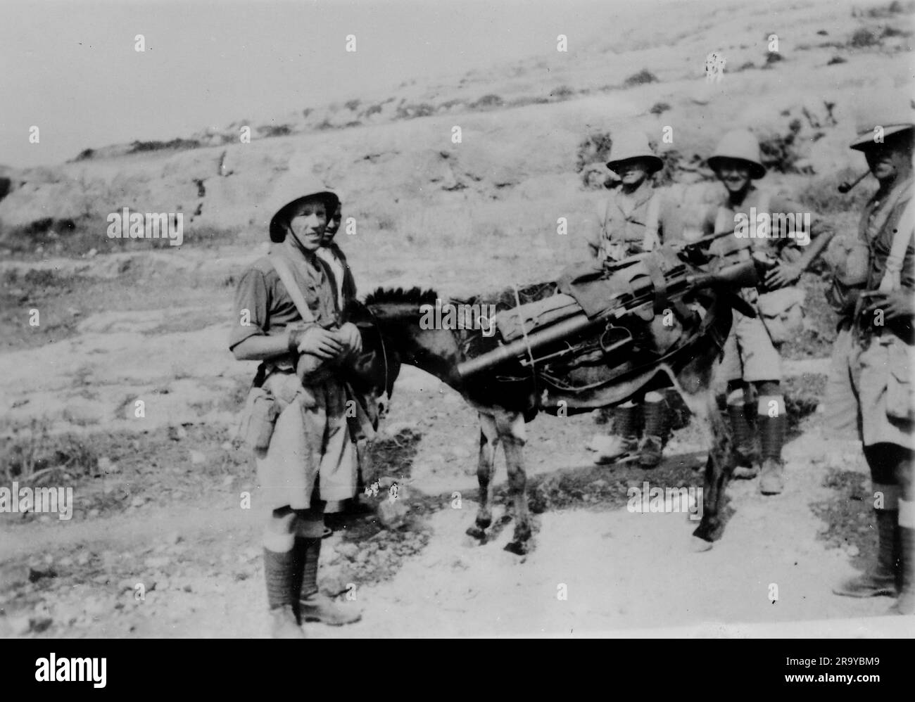 Un gruppo di soldati con un asino carico di provviste. Questa fotografia è tratta da un album fotografico di fotografie, c1937, durante l'occupazione della Palestina da parte dell'esercito britannico. La Gran Bretagna amministrò la Palestina per conto della società delle Nazioni tra il 1920 e il 1948, un periodo denominato "mandato britannico”. Foto Stock