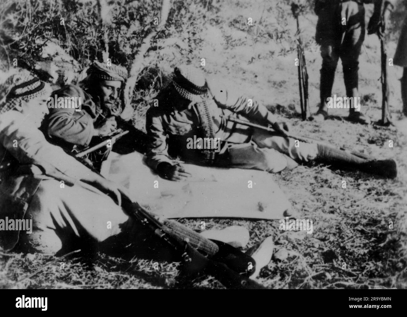Arabi in una radura che esamina una mappa o simili, parte di un gruppo descritto come "briganti" (un membro di una banda che imboscava e derubava le persone nelle foreste e nelle montagne}. Questa fotografia è tratta da un album fotografico di fotografie, c1937, durante l'occupazione della Palestina da parte dell'esercito britannico. La Gran Bretagna amministrò la Palestina per conto della società delle Nazioni tra il 1920 e il 1948, un periodo denominato "mandato britannico”. Foto Stock