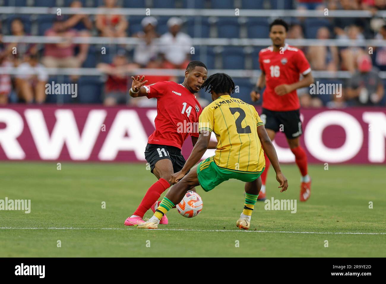 St Louis, Missouri. USA; il difensore di Trinidad e Tobago Shannon Gomez (14) dribbling la palla, mentre il difensore giamaicano Dexter Lembikisa (2) durante una Foto Stock