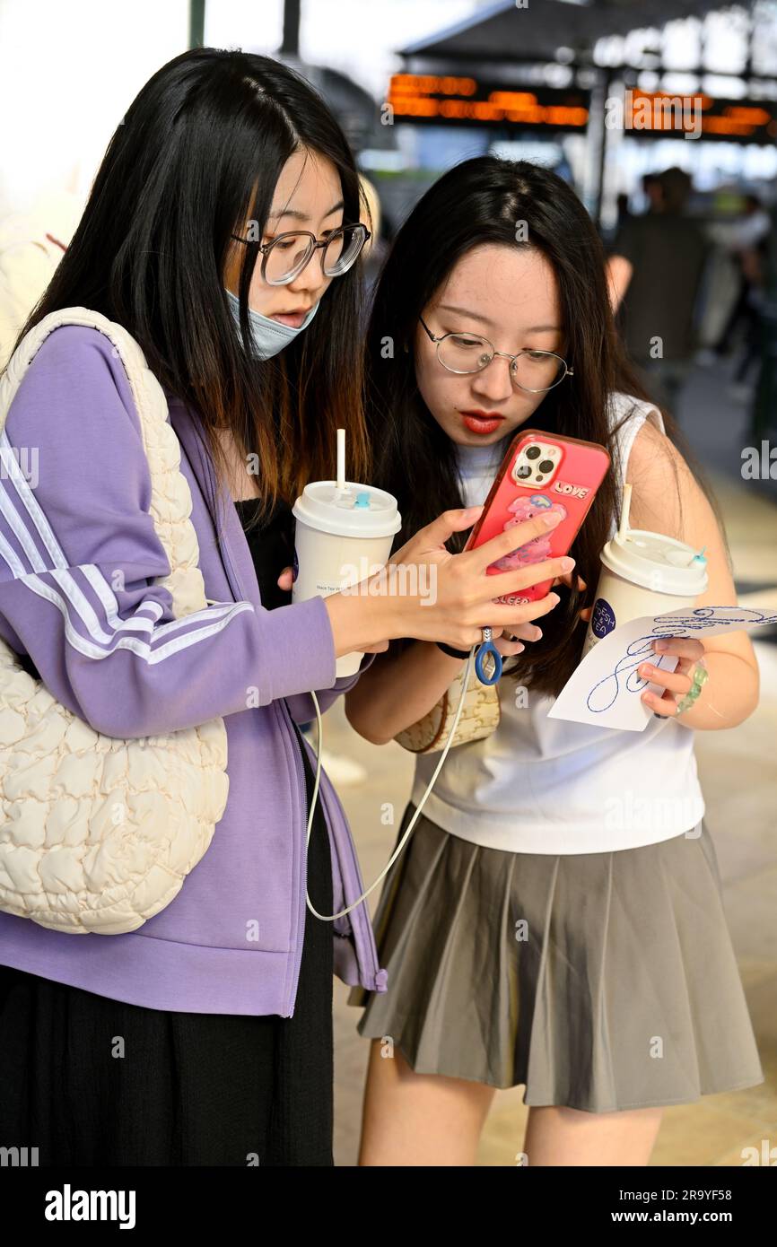 Due giovani donne turisti che guardano e controllano lo smartphone Foto Stock