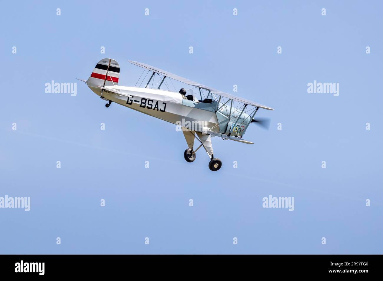 Bücher Jungmann G-BSAJ con lo schema di colori delle Olimpiadi di Berlino 1936, trasportato in aereo al Around the World Airshow tenutosi a Shuttleworth il 4 giugno 2023. Foto Stock