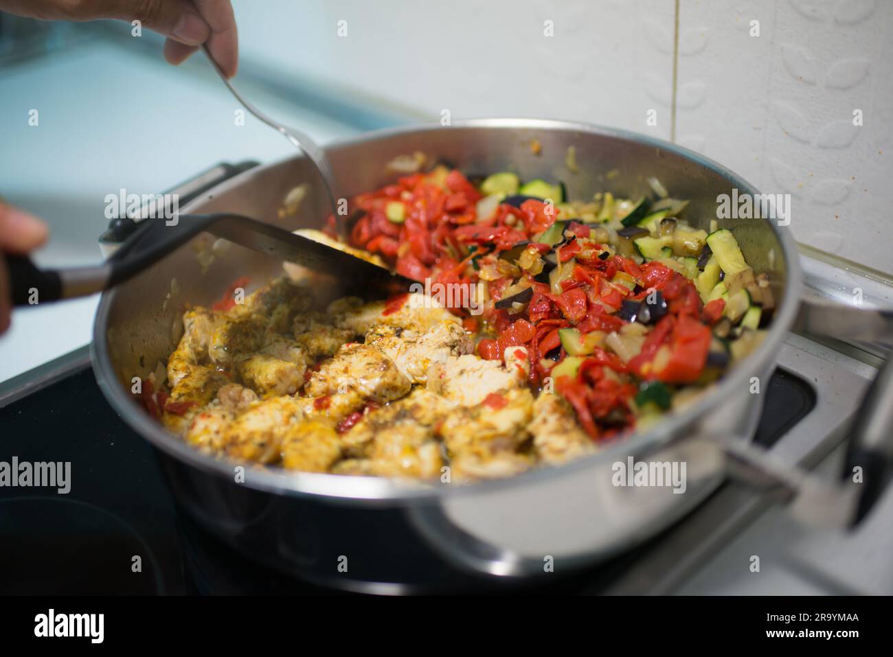Persona irriconoscibile che cucina verdure. Interni Foto Stock