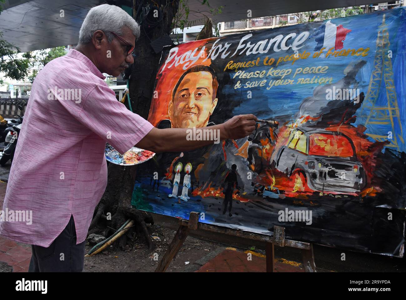 Un insegnante dipinge un poster "prega per la Francia" fuori dalla scuola d'arte Gurukul a Mumbai. Un conducente di 17 anni è stato ucciso dalla polizia che si dice si sia rifiutato di rispettare l'ordine di fermare la sua auto. Una folla arrabbiata di persone ha attaccato la stazione di polizia, i trasporti pubblici, i centri cittadini di tutto il paese. Foto Stock