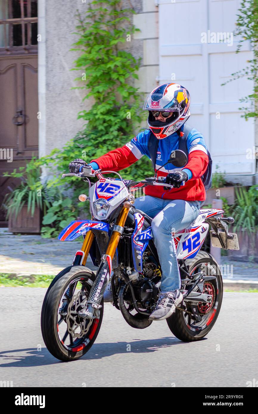 Giovane motociclista che accelera la città sulla Reiju MRT 50 - Preuilly-sur-Claise, Indre-et-Loire (37), Francia. Foto Stock