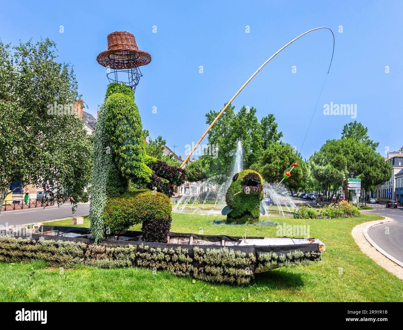 Falso topiario del pescatore seduto in barca a catturare un pesce - Chatellerault, Vienne (86), Francia. Foto Stock