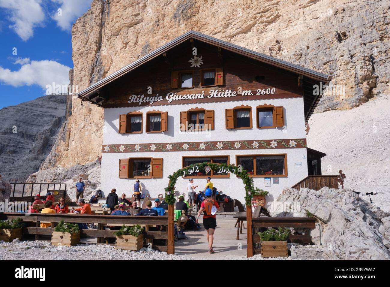 Rifugio Camillo Giussani Hutte, rifugio situato a forcella Fontananegra, gruppo montuoso di Tofane, con persone sedute all'aperto, con bel tempo in estate Foto Stock