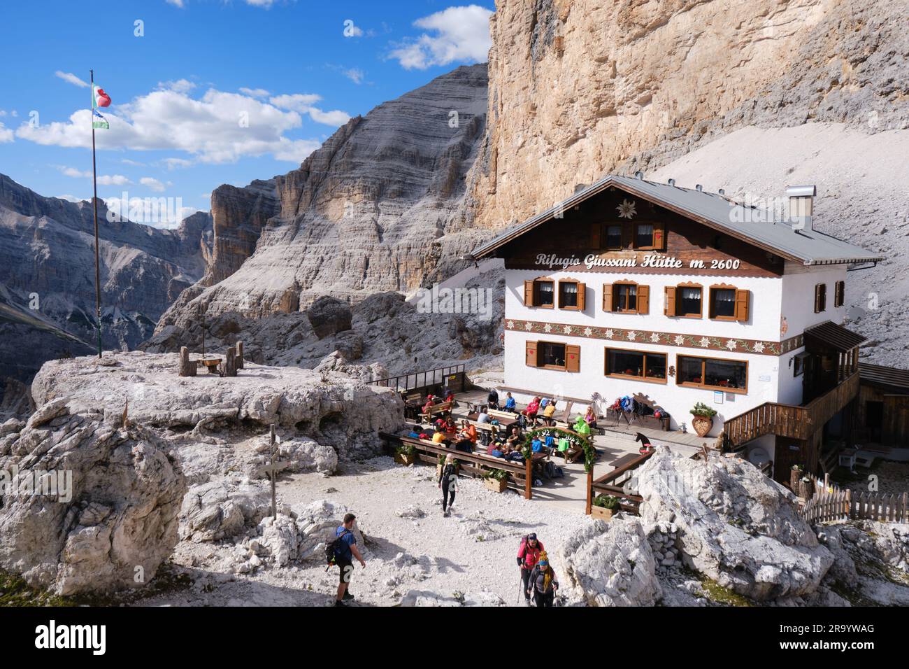 Rifugio Camillo Giussani Hutte, rifugio situato a forcella Fontananegra, gruppo montuoso di Tofane, con persone sedute all'aperto, con bel tempo in estate Foto Stock