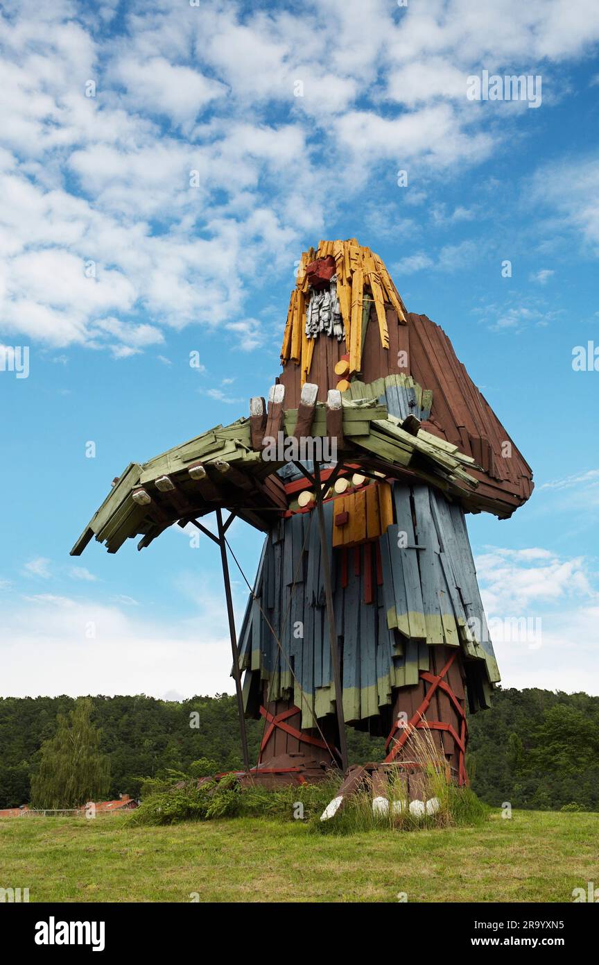 Vista angolare di un'enorme scultura di troll in legno sotto il cielo nuvoloso. Huskvarna, Svezia. Foto Stock