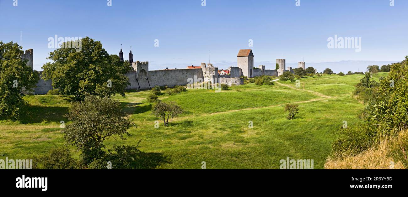 Foto panoramica del paesaggio verde con le mura della città sullo sfondo su sfondo blu chiaro, Visby, isola di Gotland, Svezia. Foto Stock