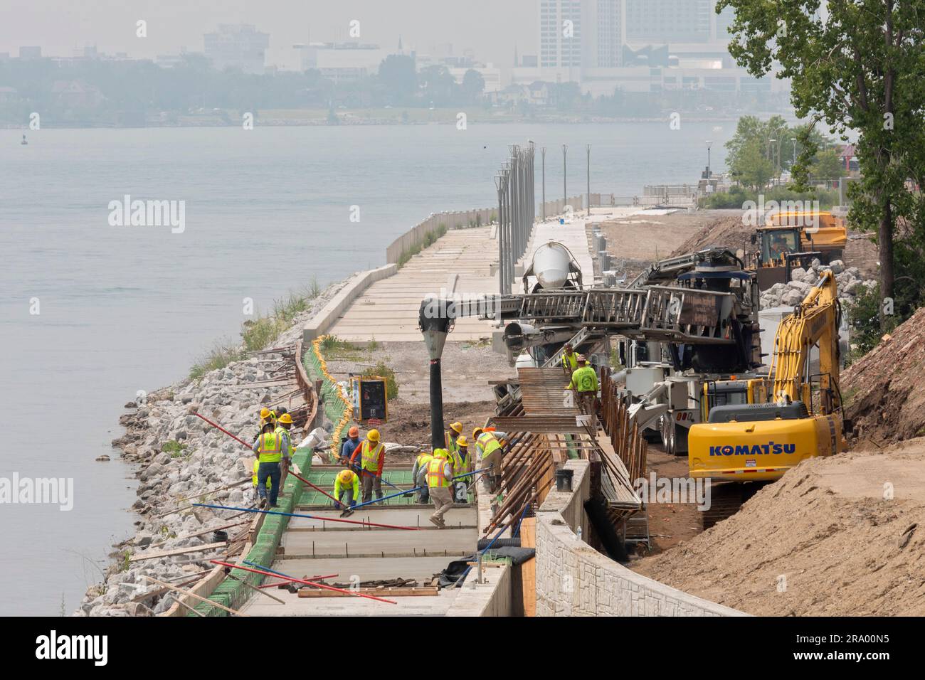 Detroit, Michigan - i lavoratori versano cemento per completare una sezione del lungofiume di Detroit sul sito dell'ex fabbrica di pneumatici Uniroyal. La passeggiata/bi Foto Stock