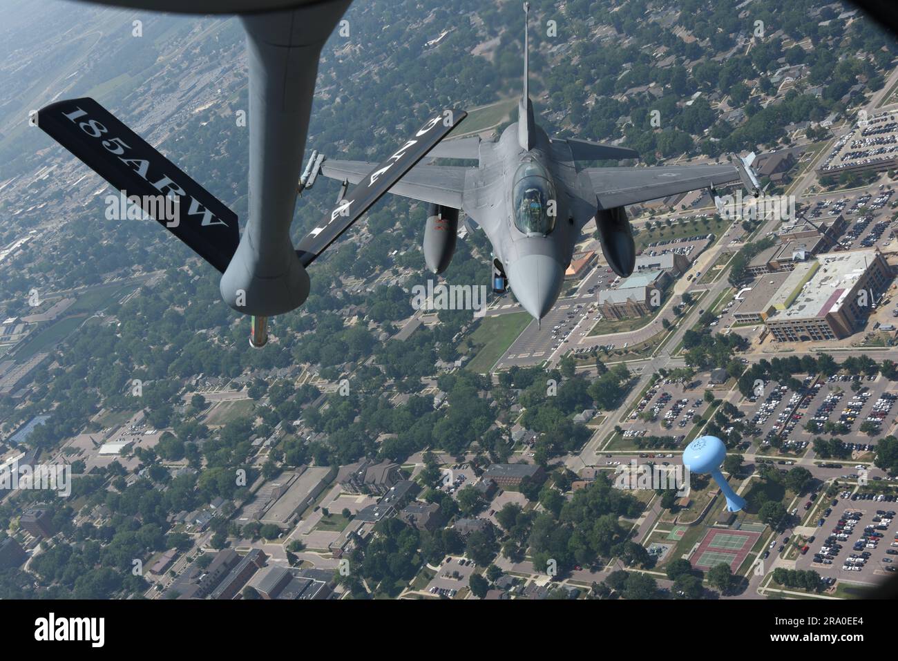 UN U.S. Air Force F-16 Falcon del 114th Fighter Wing della South Dakota Air National Guard che vola con un U.S. Air Force KC-135 Stratotanker del 185th Air Refueling Wing della Iowa Air National Guard passa sopra Sioux Falls, S.D. il 27 giugno 2023. L'aereo fa parte di una dimostrazione di rifornimento aereo a livello nazionale, che commemora il 100° anniversario del rifornimento aereo. STATI UNITI Foto della Guardia Nazionale dell'aria, Senior Master Sgt. Vincent De Groot Foto Stock