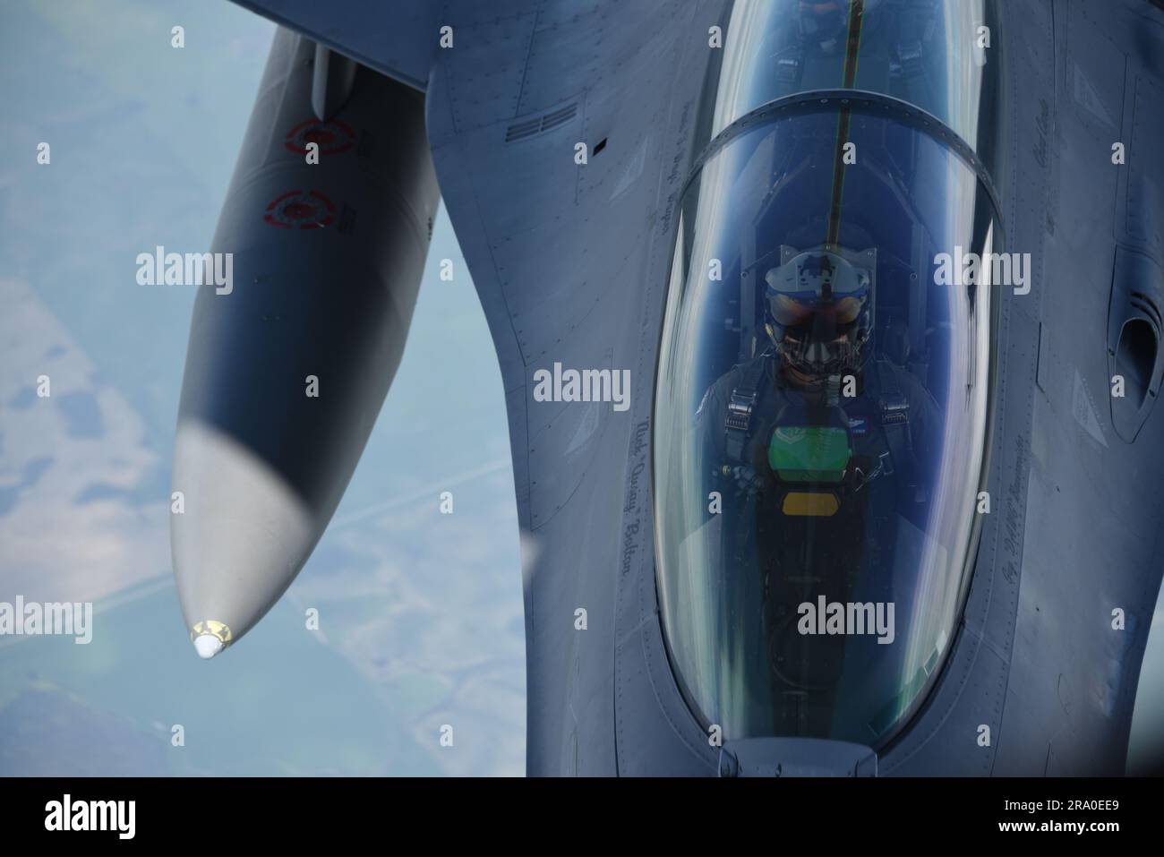 Un pilota di F-16 con il 114th Fighter Wing della South Dakota Air National Guard guarda in alto mentre vola sotto un KC-135 per ricevere carburante sul Sud-Est del Dakota il 27 giugno 2023. STATI UNITI Foto della Guardia Nazionale dell'aria, Senior Master Sgt. Vincent De Groot Foto Stock