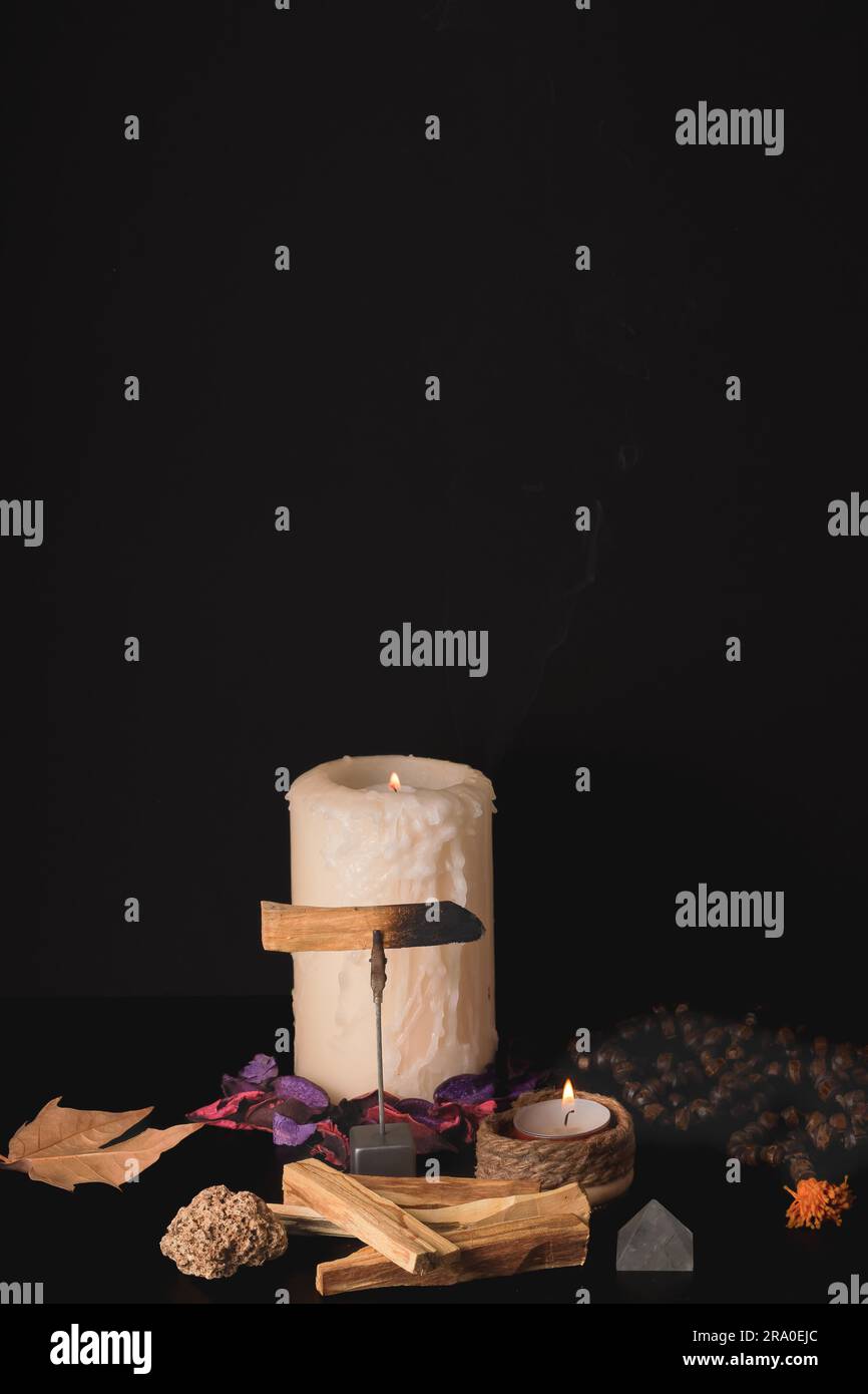 palo santo con candele accese e japa mala su sfondo nero Foto Stock