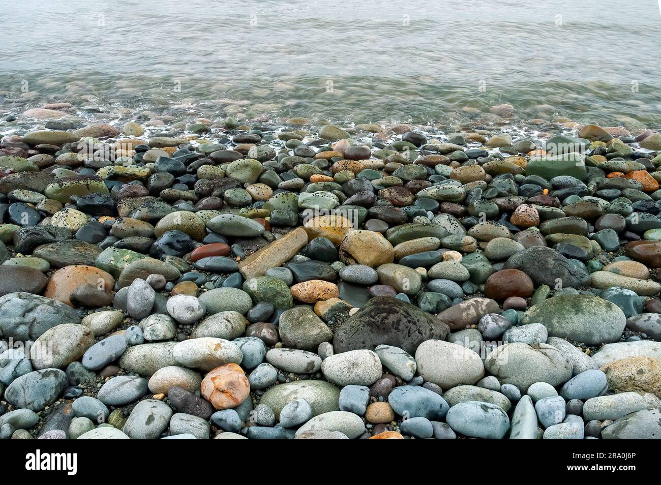 Closeup di rocce colorate arrotondate e oceano, Lima, Perù.. Foto Stock