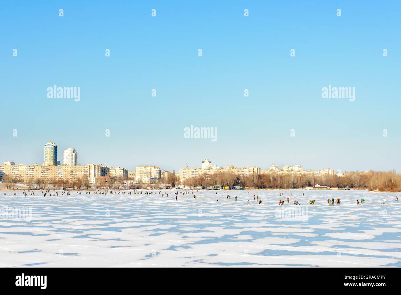 Kiev Ucraina - 7 gennaio 2015 - il fiume Dnieper è ghiacciato. Centinaia di pescatori vanno a pescare un po' di pesce sotto il basso sole invernale Foto Stock