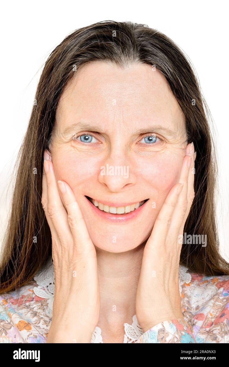 Ritratto di un sorridenti donna matura, con le mani sul viso Foto Stock