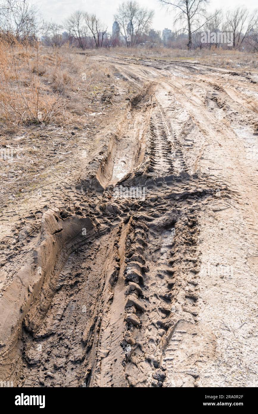 Profonde tracce di pneumatici sulla strada coperta da bagnato sabbia fangose Foto Stock