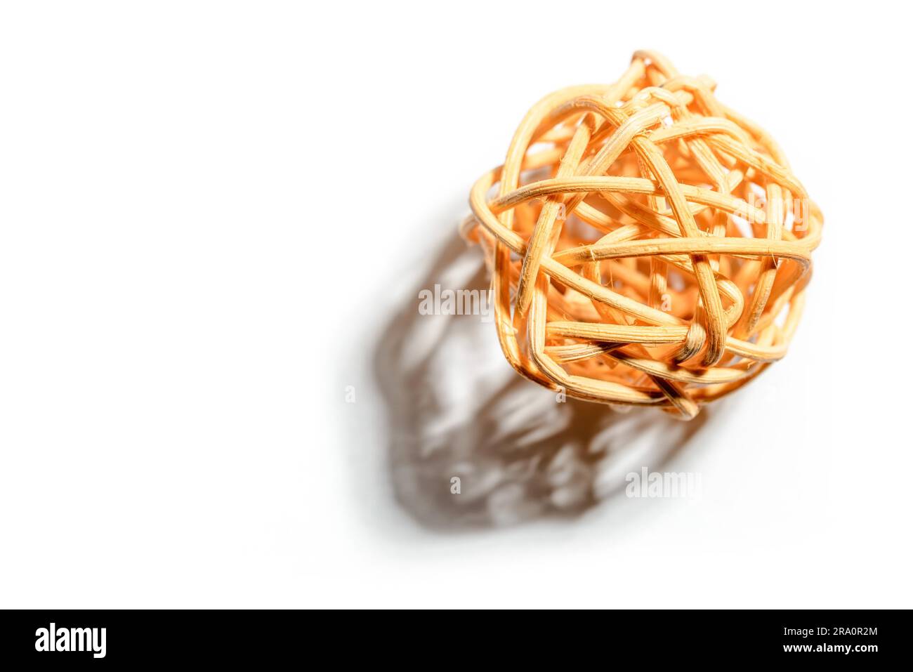 Una palla di vimini con una forte ombra, isolata su bianco. Spazio libero per il testo Foto Stock