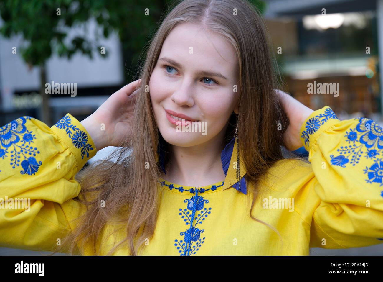 Le mani di una giovane ragazza reggono la bandiera Ucraina. Una ragazza con una camicia ricamata. Ucraina libera. Foto di alta qualità Foto Stock