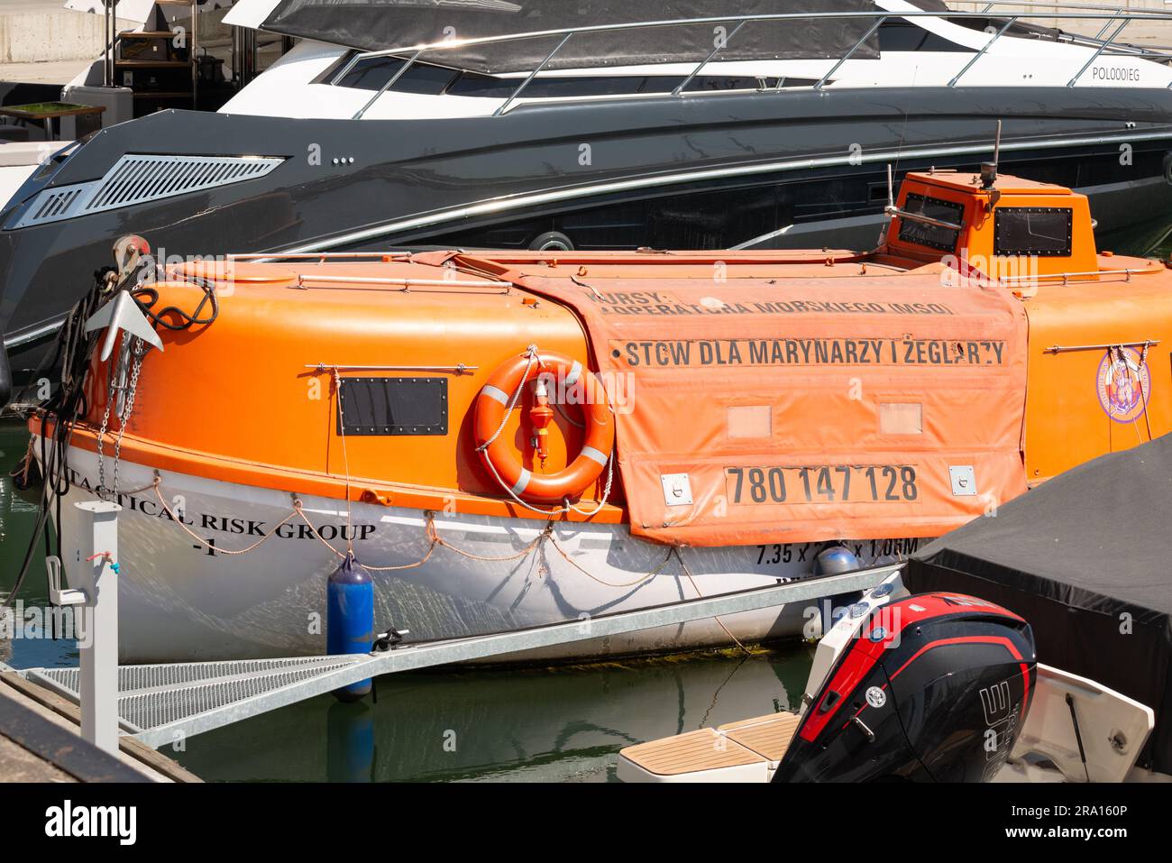 Gruppo tattico di rischio: Scialuppa di salvataggio arancione o barca di salvataggio tra gli yacht del Marina Yacht Park di Gdynia, Polonia, Europa, UE Foto Stock