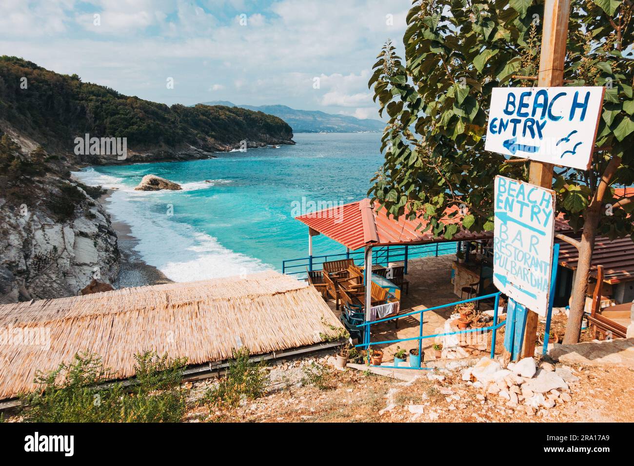 Un cartello dipinto a mano indica l'ingresso della spiaggia di Pulëbardha a Ksamil, Albania Foto Stock