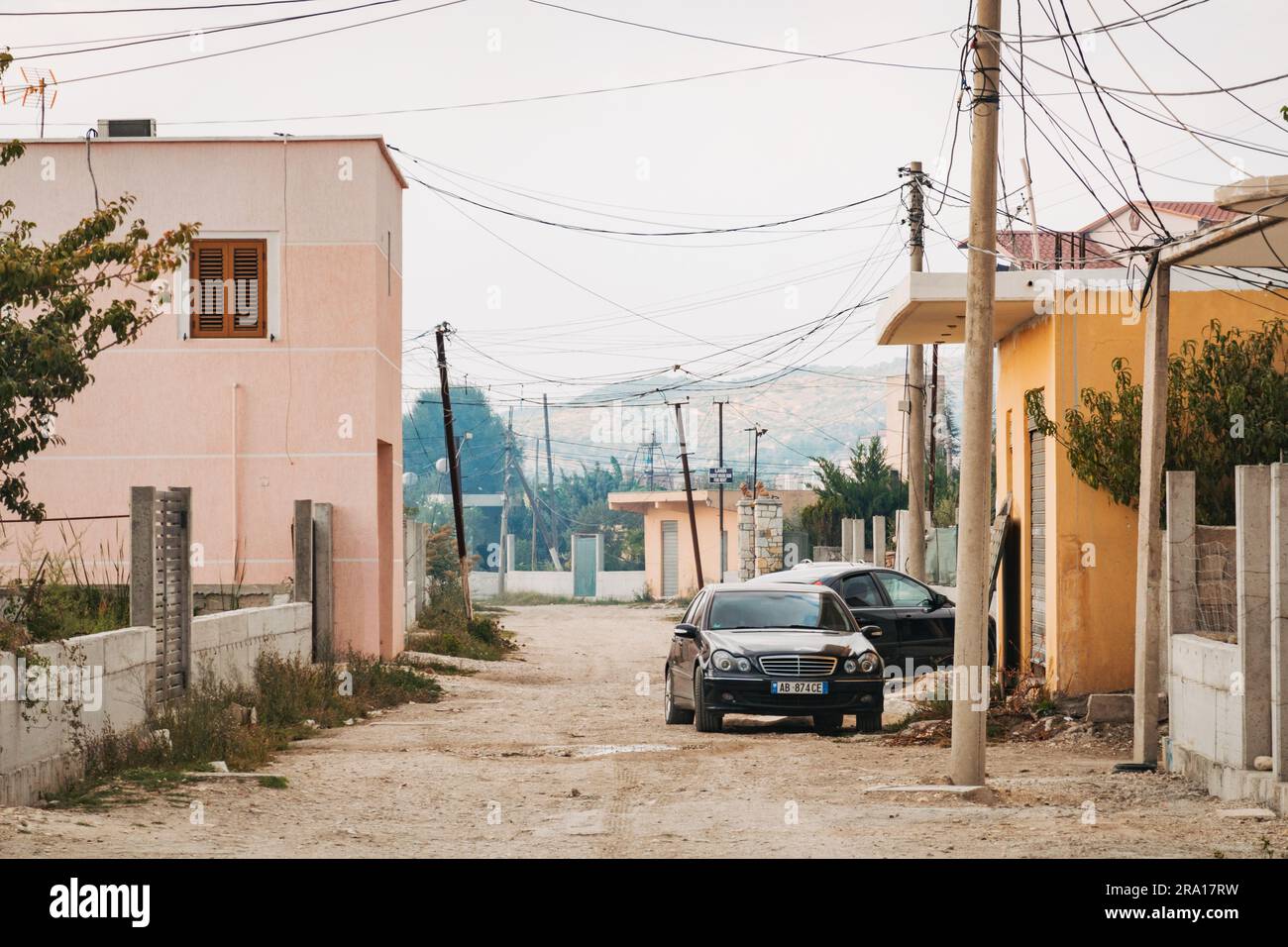 Una strada suburbana sterrata nella città costiera di Vlorë, nel sud dell'Albania Foto Stock