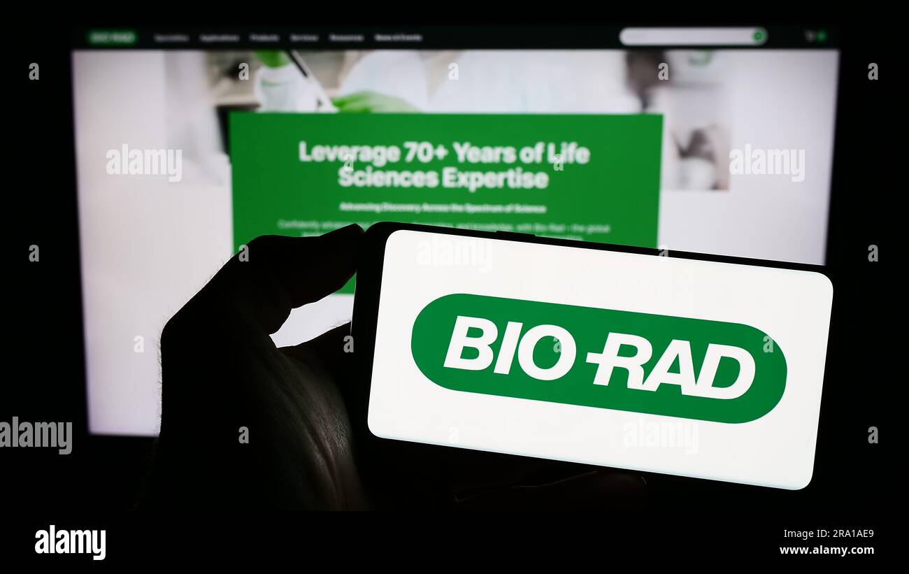 Persona che possiede uno smartphone con il logo della società statunitense Bio-Rad Laboratories Inc. Sullo schermo davanti al sito Web. Concentrarsi sul display del telefono. Foto Stock