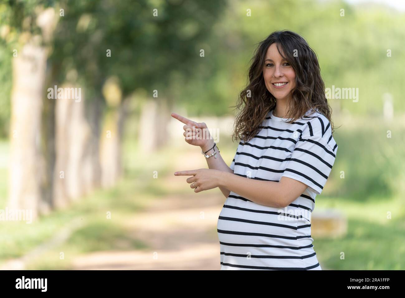 Foto con spazio copia per inserire qualcosa con una donna incinta puntando Foto Stock