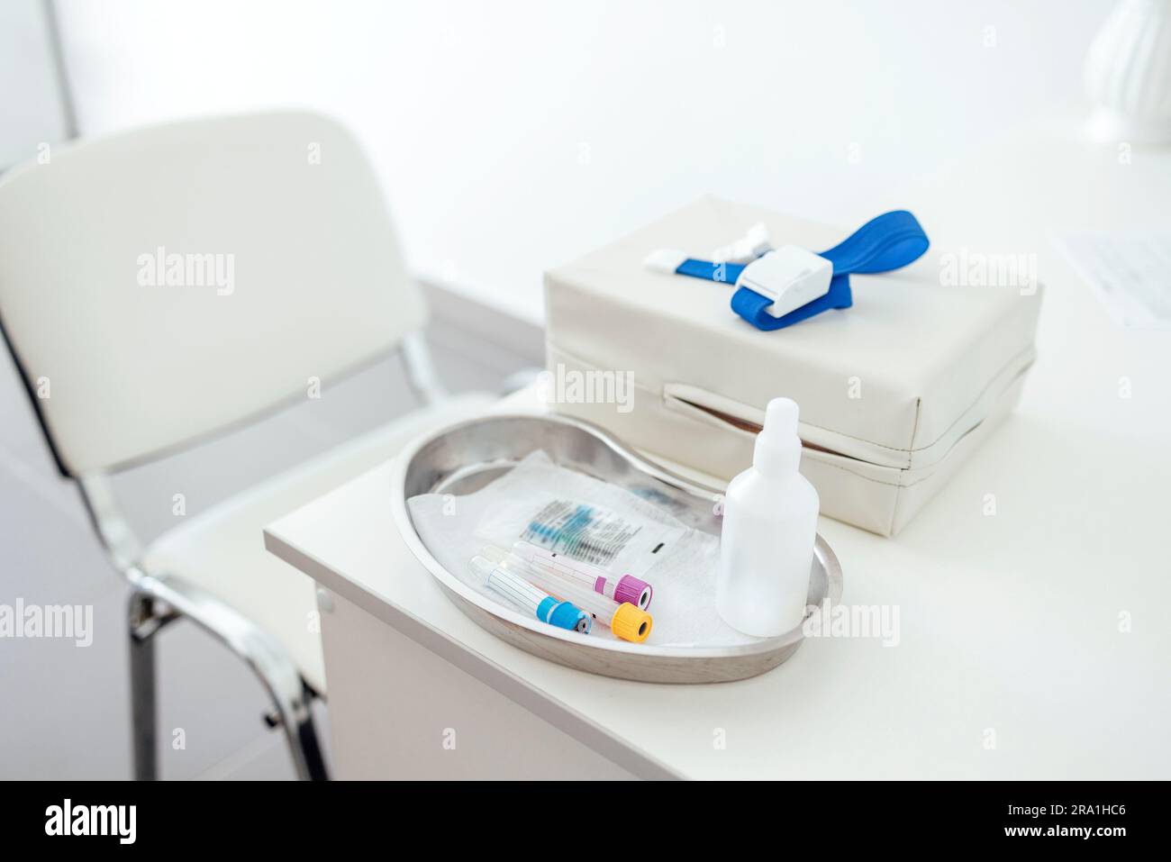 Il desktop di un medico o di un infermiere. Dispositivi per il prelievo ematico su un tavolo bianco. Pacchetto procedurale. Laccio emostatico medico. Provette per il sangue, aghi, pisolino Foto Stock