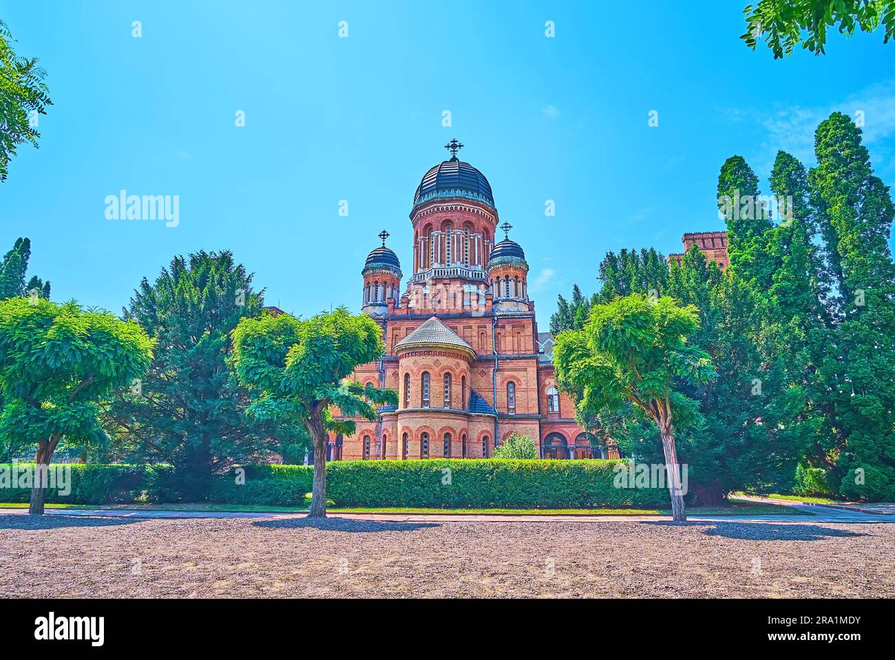 Chiesa del Seminario storico dell'Università Nazionale di Chernivtsi con lussureggiante giardino verde intorno ad essa, Ucraina Foto Stock