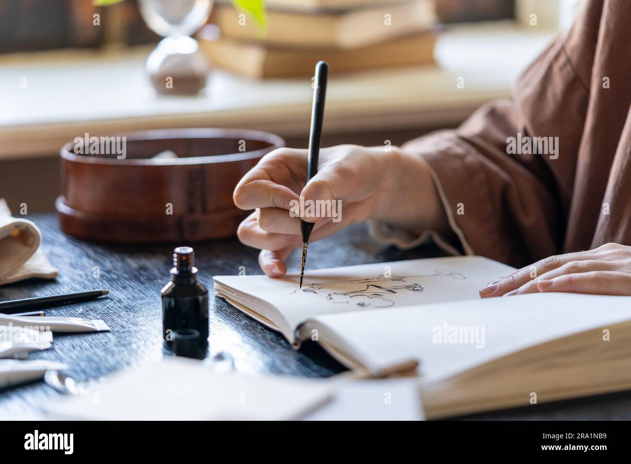Artista che utilizza il disegno a penna in un libro di schizzi con inchiostro nero Foto Stock