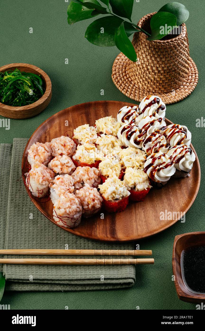 Set di sushi panini asiatici con tappi di formaggio su un piatto di legno Foto Stock