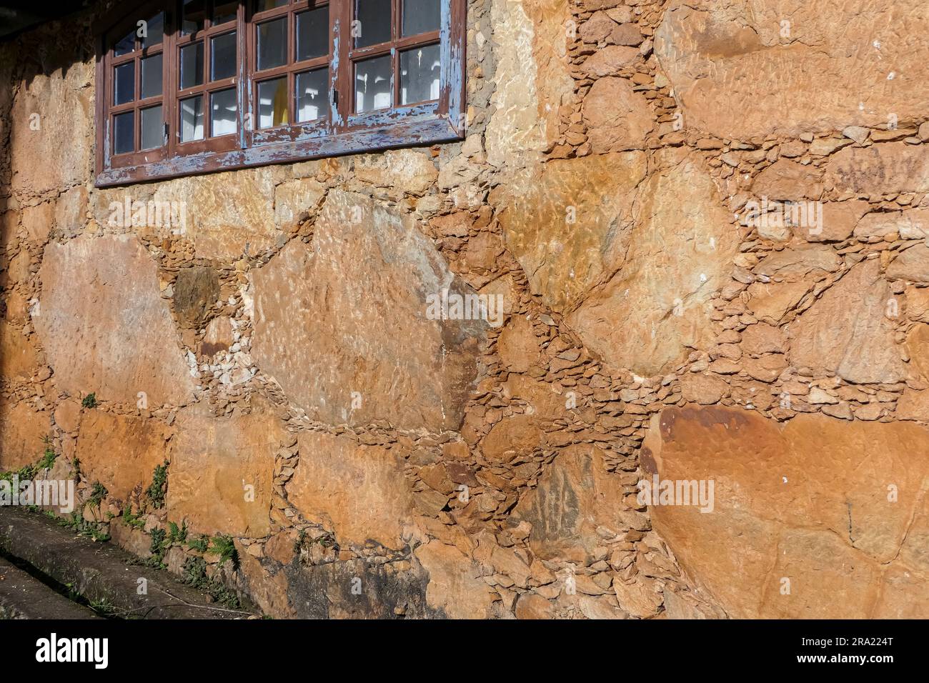 Tipico muro di arenaria di un vecchio edificio coloniale con finestra, Minas Gerais, Brasile Foto Stock