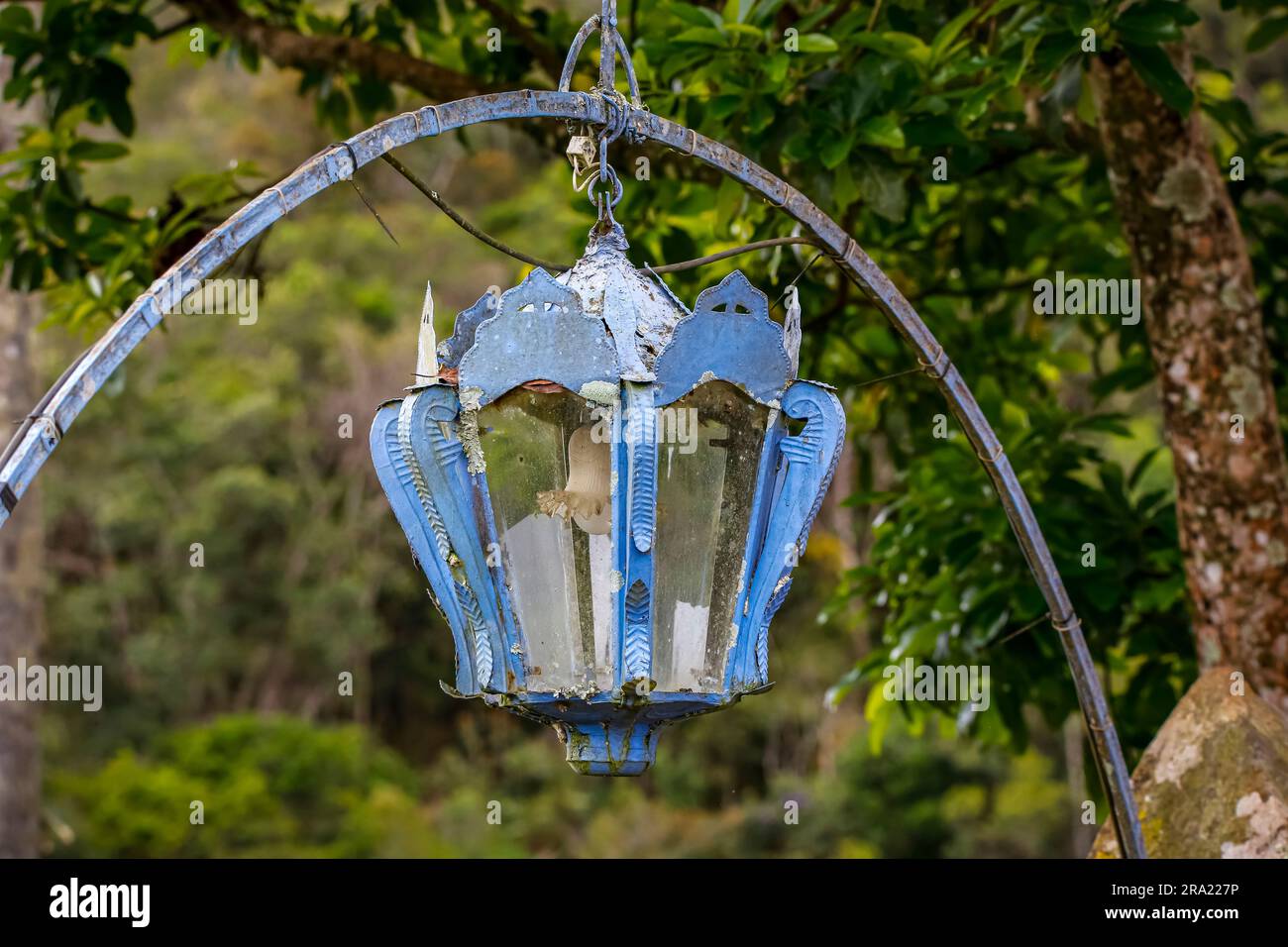 Lanterna appesa ad un arco di metallo blu su sfondo verde, Minas Gerais, Brasile Foto Stock