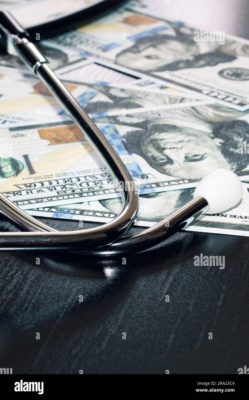 Stetoscopio su cento dollari bollette primo piano, costo della medicina Foto Stock