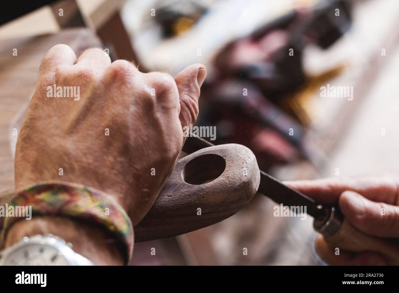 Dettaglio delle mani dell'artigiano utilizzando una lima per arrotondare un pezzo di legno. Foto Stock