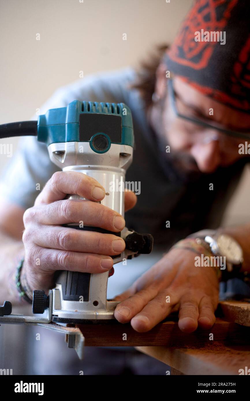Woodworker che utilizza un router per la lavorazione del legno. Foto Stock