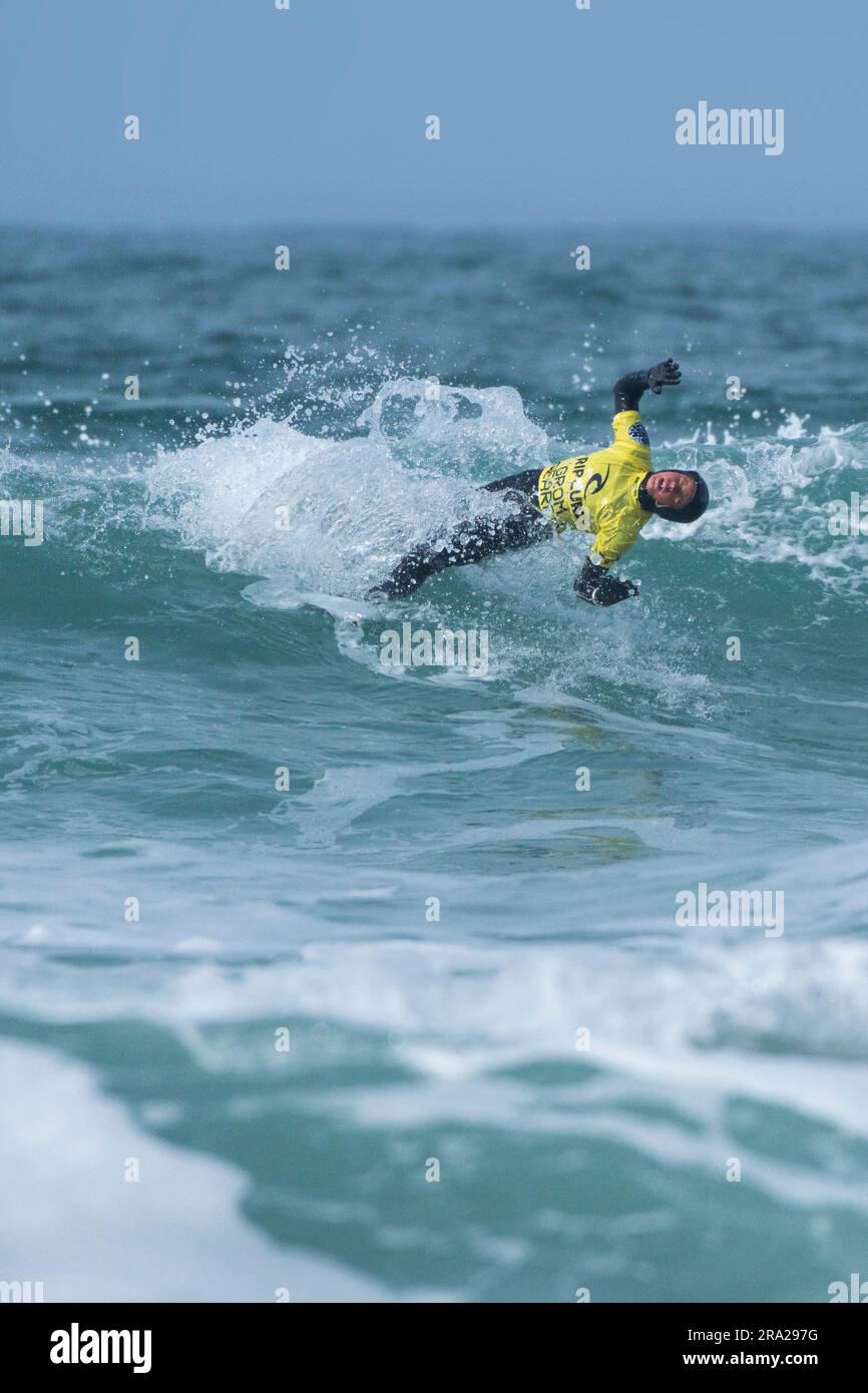 Una visione di un giovane surfista maschio che si spazza via in un'onda durante la gara di surf Rip Curl Grom Search a Fistral a Newquay in Cornovaglia, nel Regno Unito Foto Stock