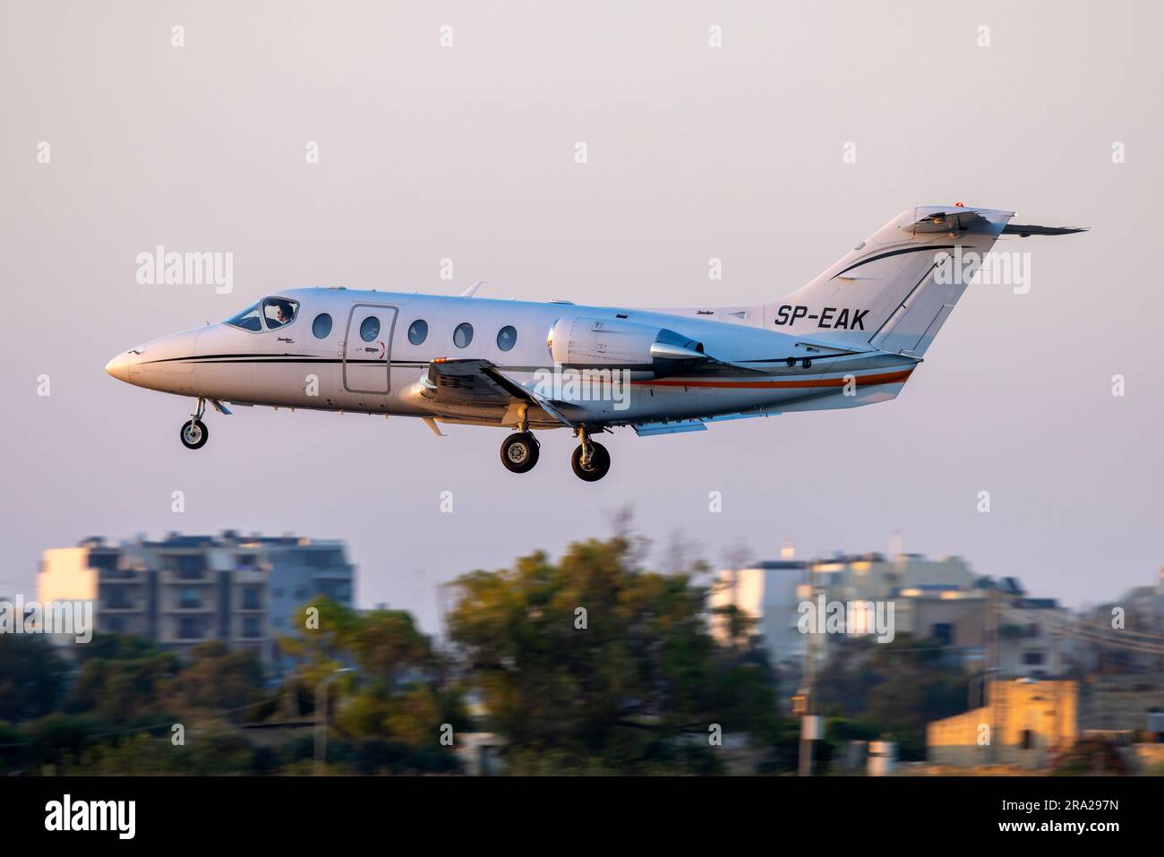 Hawker Beechcraft 400XP (REG: SP-EAK) in finale proprio mentre il sole tramonta all'orizzonte. Foto Stock