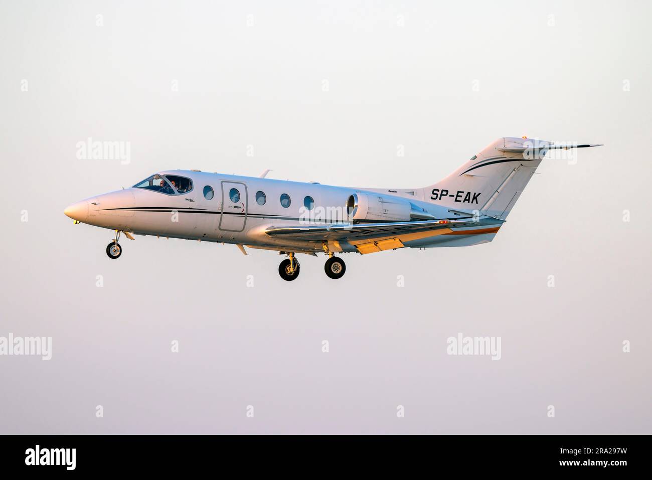 Hawker Beechcraft 400XP (REG: SP-EAK) in finale proprio mentre il sole tramonta all'orizzonte. Foto Stock