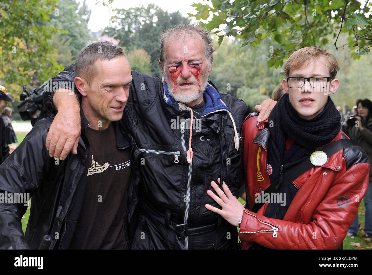ARCHIVIATO - 30 settembre 2010, Baden-Württemberg, Stoccarda: Due uomini sostengono Dietrich Wagner (M), ferito da un cannone ad acqua, nello Schlossgarten di Stoccarda dopo una dimostrazione contro il progetto ferroviario di Stoccarda 21. Era stato gravemente ferito agli occhi dal jet di un cannone d'acqua durante la dura azione della polizia contro gli avversari di Stoccarda 21 il 30 settembre 2010. Il giorno delle proteste è diventato noto come "giovedì nero”. (A dpa 'quasi accecato Stuttgart-21 avversario Wagner è morto') foto: Picture Alliance / dpa Foto Stock