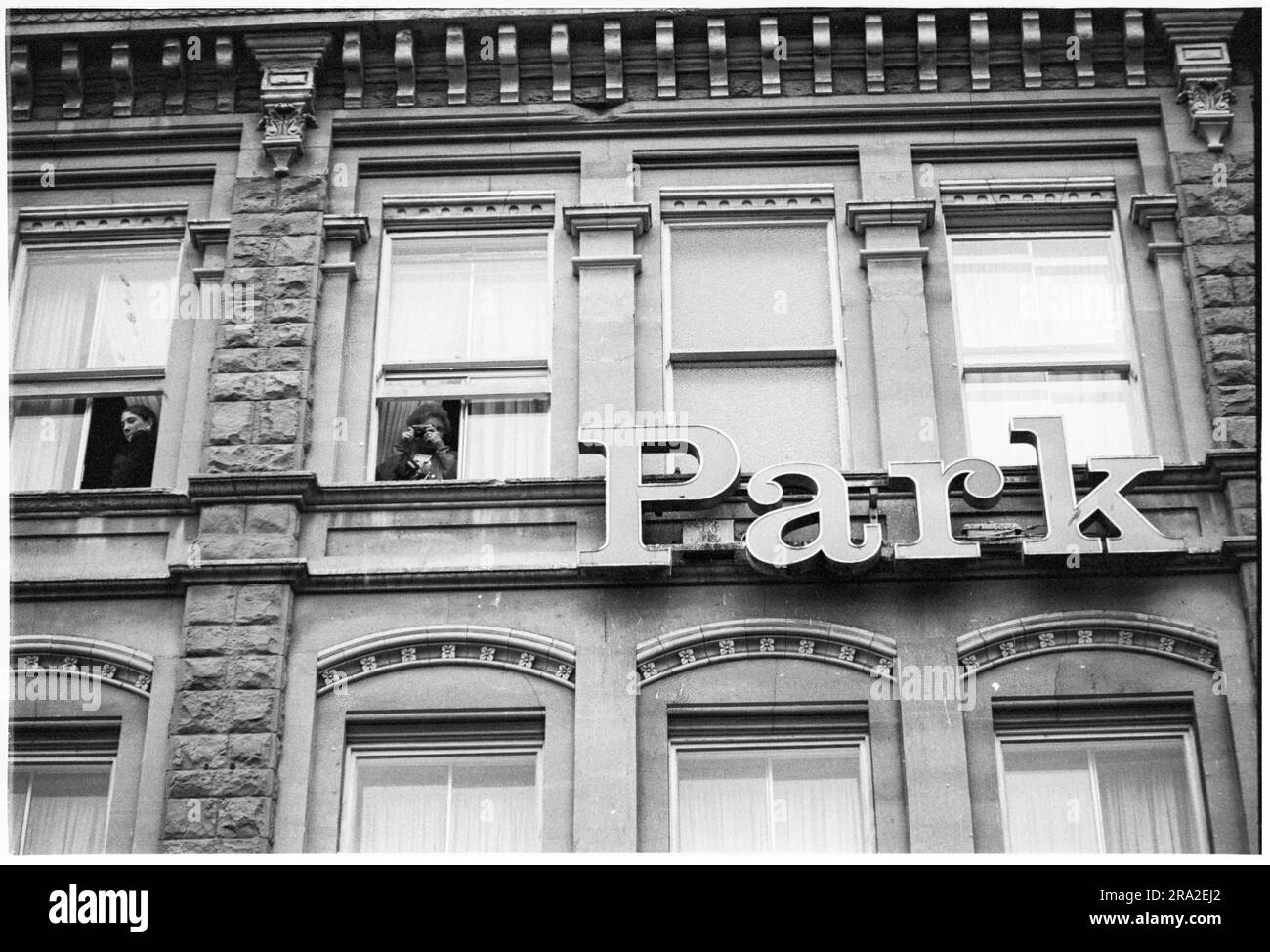 I lavoratori in ufficio guardano dalle finestre mentre i Bon Jovi giocano un concerto gratuito sul palco di Queen Street, Cardiff, Galles, Regno Unito il 21 giugno 1995. Il concerto era quello di pubblicizzare il concerto poco venduto all'Arms Park Stadium il giorno successivo. Foto: Rob Watkins Foto Stock