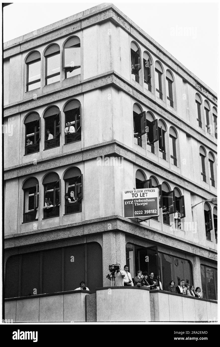 BON JOVI, CONCERTO GRATUITO, CARDIFF BANDSTAND, 1995: Gli impiegati guardano dalle finestre mentre Bon Jovi suonano un concerto gratuito sul palco di Queen Street, Cardiff, Galles, Regno Unito, il 21 giugno 1995. Il concerto era quello di pubblicizzare il concerto poco venduto all'Arms Park Stadium il giorno dopo. Foto: Rob Watkins Foto Stock