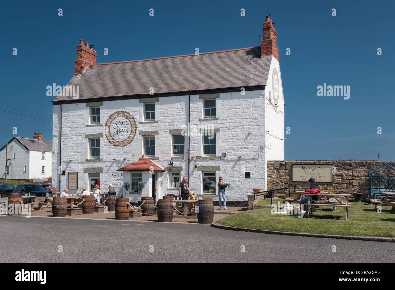 I clienti che si godono il sole estivo nel giardino del pub del Kings Arms Public House presso Seaton Sluice sulla costa del Northumberland Foto Stock