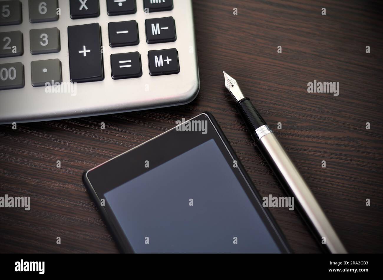 calcolatrice, stilografica e smartphone sul tavolo Foto Stock